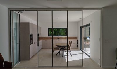 Installation d'un système coulissant-pivotant tout verre effet verrière dans une villa contemporaine basée dans le Rhône (69)