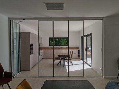 Installation d'un système coulissant-pivotant tout verre effet verrière dans une villa contemporaine basée dans le Rhône (69)