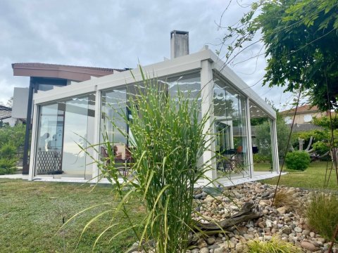 Installation d’une toiture vitrée sur-mesure et de coulissants pivotants : élégance et transparence pour une charmante maison dans l’Ain (01)