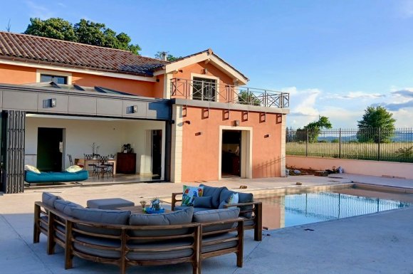 Rénovation et extension d’une habitation d’exception près de Villefranche-sur-Saône (69), intégrant des baies accordéon, une toiture vitrée et des stores sur-mesure.