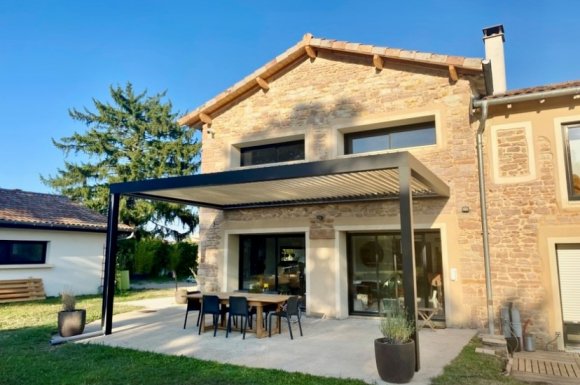 Pose d'une pergola bioclimatique sur mesure de dimensions exceptionnelles : Intégration parfaite dans une façade en pierre à Macon (71)