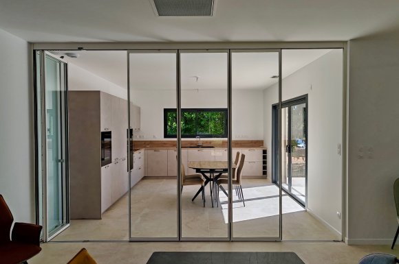 Installation d'un système coulissant-pivotant tout verre effet verrière dans une villa contemporaine basée dans le Rhône (69)