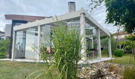 Installation d’une toiture vitrée sur-mesure et de coulissants pivotants : élégance et transparence pour une charmante maison dans l’Ain (01)