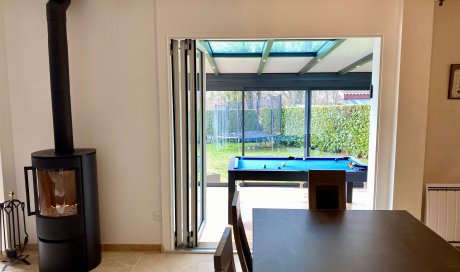 Remplacement d’une baie coulissante par une baie accordéon sur-mesure pour une ouverture totale sur la véranda près de Trévoux (01)