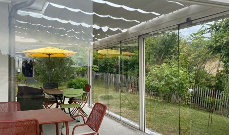 Installation d’une toiture vitrée sur-mesure et de coulissants pivotants : élégance et transparence pour une charmante maison dans l’Ain (01)