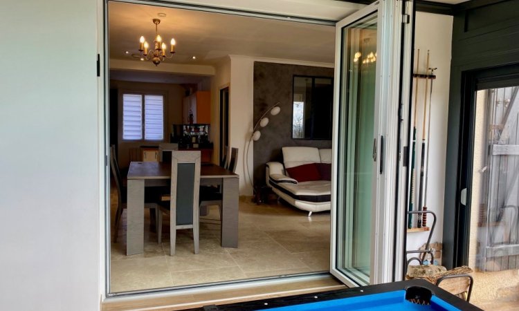 Nouveauté dans l'Ain (01) : Remplacement d’une baie coulissante par une baie accordéon sur-mesure pour une ouverture totale sur la véranda..