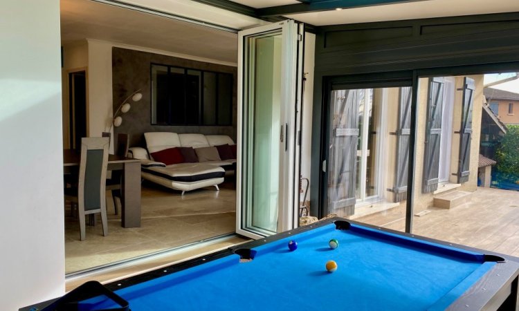 Nouveauté dans l'Ain (01) : Remplacement d’une baie coulissante par une baie accordéon sur-mesure pour une ouverture totale sur la véranda..