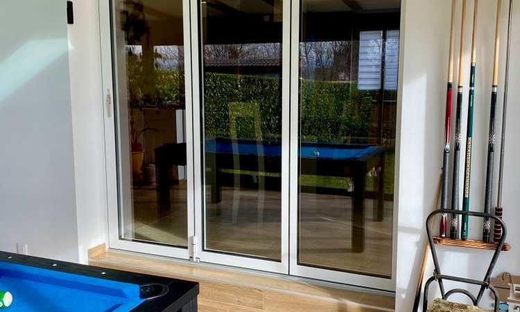 Nouveauté dans l'Ain (01) : Remplacement d’une baie coulissante par une baie accordéon sur-mesure pour une ouverture totale sur la véranda..