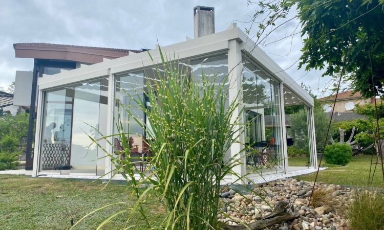 Installation d’une toiture vitrée sur-mesure et de coulissants pivotants : élégance et transparence pour une charmante maison dans l’Ain (01)