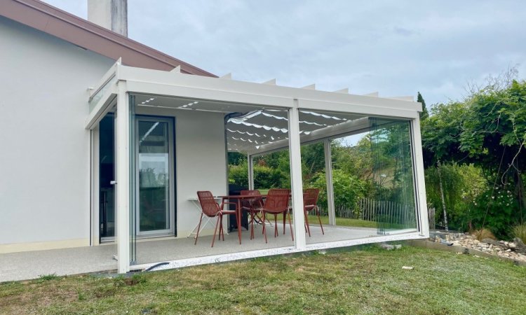 Installation d’une toiture vitrée sur-mesure et de coulissants pivotants : élégance et transparence pour une charmante maison dans l’Ain (01)