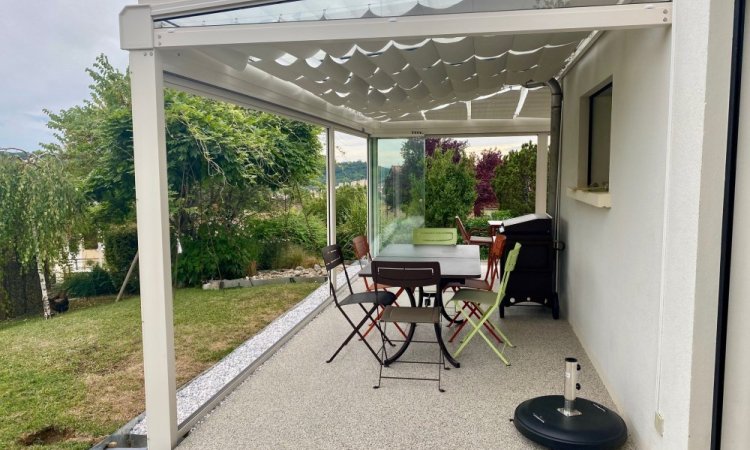 Installation d’une toiture vitrée sur-mesure et de coulissants pivotants : élégance et transparence pour une charmante maison dans l’Ain (01)