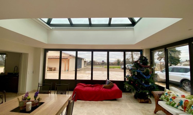 Rénovation et extension d’une habitation d’exception près de Villefranche-sur-Saône (69), intégrant des baies accordéon, une toiture vitrée et des stores sur-mesure.