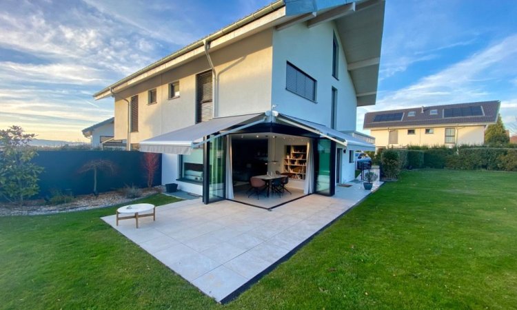 Splendide extension de pièce de vie réalisée grâce à une baie accordéon d’angle, offrant une ouverture maximale sur l’extérieur.