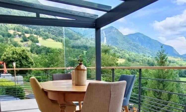 Pose d'une pergola vitrée équipée de coulissants pour profiter d'une vue époustouflante sur la région Haute-Savoie. 