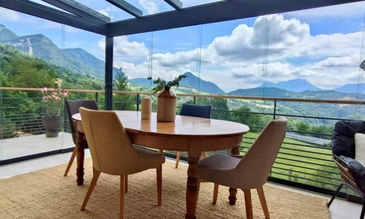 Mise en place d'une pergola vitrée munie de coulissants pour admirer une vue imprenable sur la région Haute-Savoie.