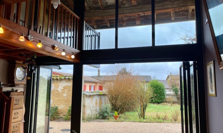 Installation sur-mesure de baies accordéon et d'un châssis fixe dans une charmante maison située dans l'Ain