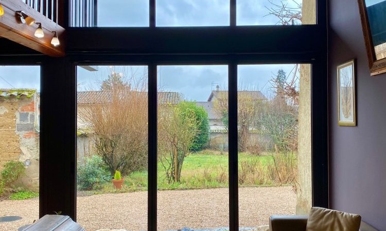 Mise en  place de baies accordéon et d'un châssis fixe dans une charmante maison située dans l'Ain