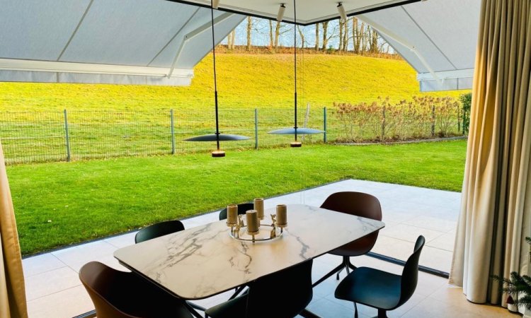 Splendide extension de pièce de vie réalisée grâce à une baie accordéon d’angle, offrant une ouverture maximale sur l’extérieur.