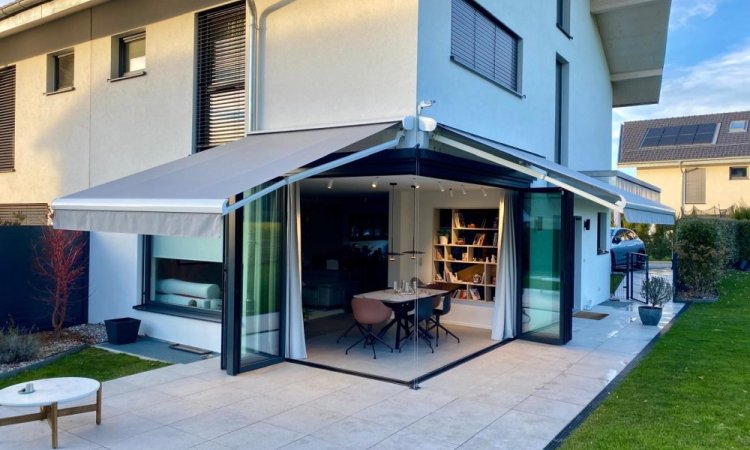 Splendide extension de pièce de vie réalisée grâce à une baie accordéon d’angle, offrant une ouverture maximale sur l’extérieur.