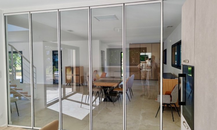 Installation d'un système coulissant-pivotant tout verre effet verrière dans une villa contemporaine basée dans le Rhône (69)