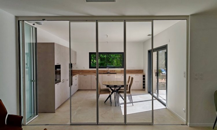 Installation d'un système coulissant-pivotant tout verre effet verrière dans une villa contemporaine basée dans le Rhône (69)