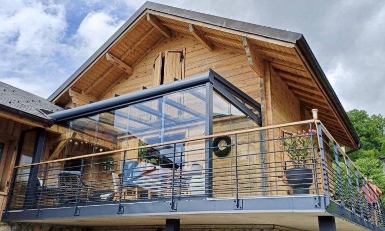 Installation d'une pergola entièrement vitrée équipée de coulissants pour profiter d'une vue sur la région Haute-Savoie.