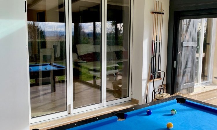Remplacement d’une baie coulissante par une baie accordéon sur-mesure pour une ouverture totale sur la véranda près de Trévoux (01)
