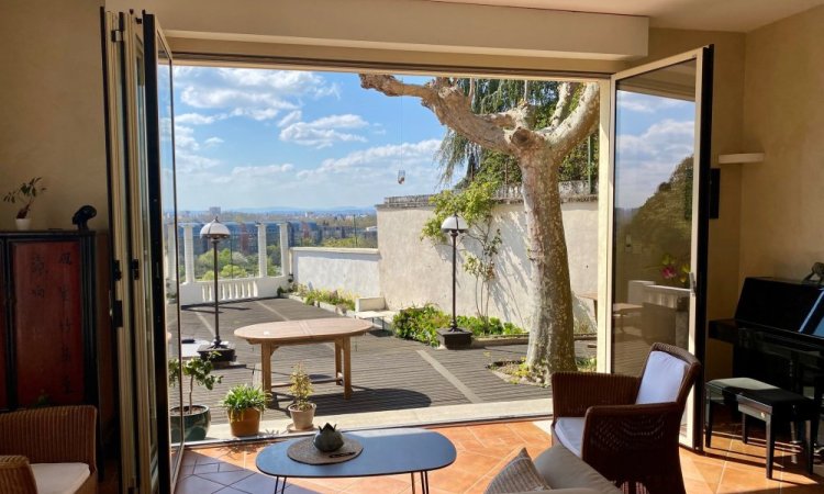 Remplacement d’une baie accordéon en bois par un modèle en aluminium dans une villa surplombant Lyon. 