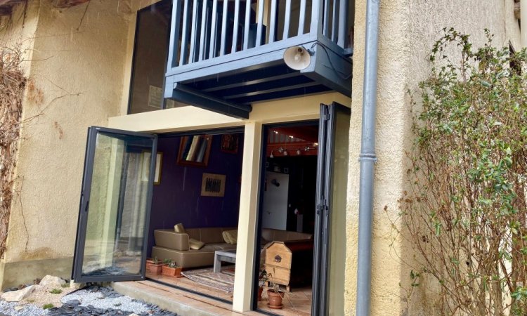 Mise en place de baies accordéon et d'un châssis fixe dans une charmante maison située dans l'Ain