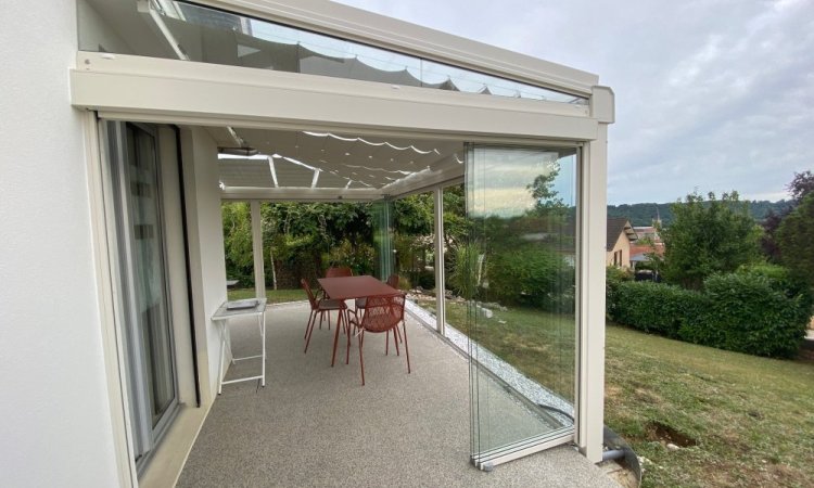 Installation d’une toiture vitrée sur-mesure et de coulissants pivotants : élégance et transparence pour une charmante maison dans l’Ain (01)