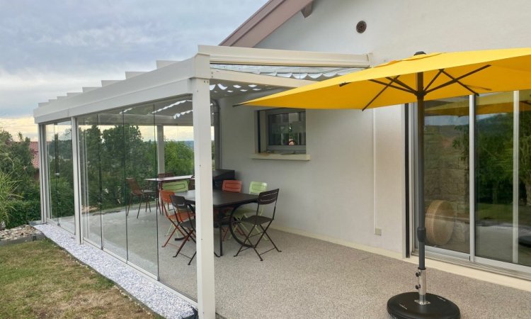 Installation d’une toiture vitrée sur-mesure et de coulissants pivotants : élégance et transparence pour une charmante maison dans l’Ain (01)