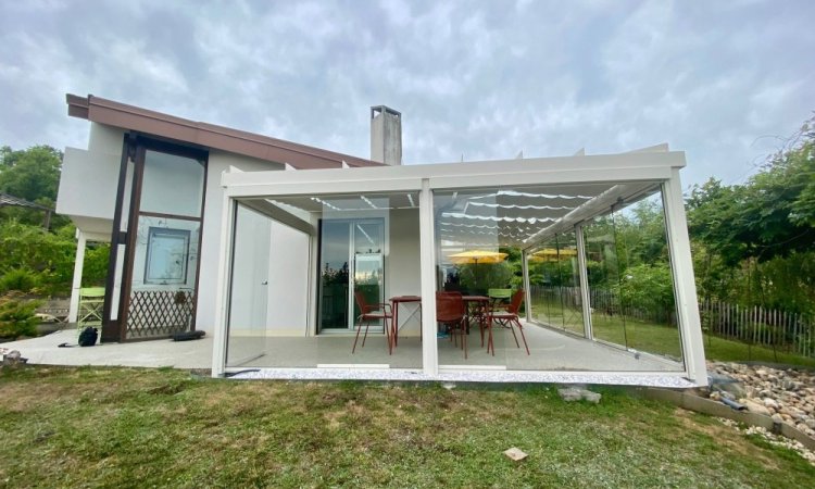 Installation d’une toiture vitrée sur-mesure et de coulissants pivotants : élégance et transparence pour une charmante maison dans l’Ain (01)